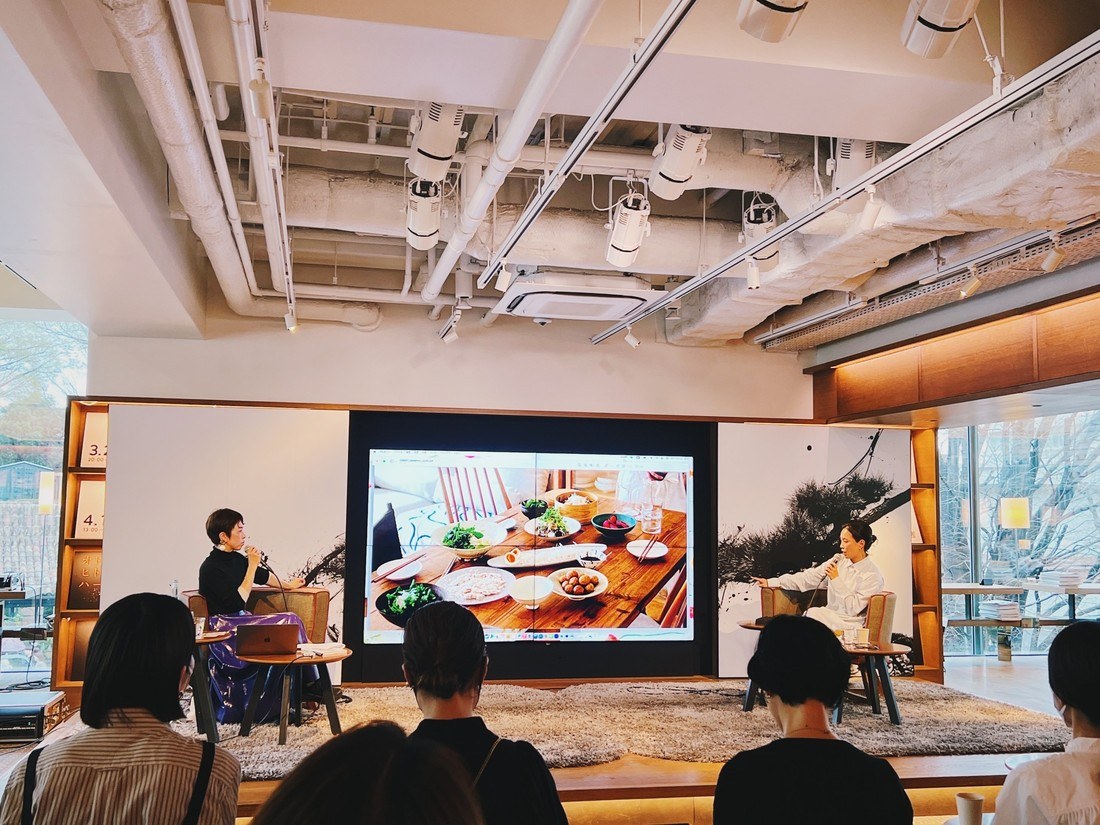 3号館2階シェアラウンジでのトークイベント。スクリーンにポスターの食卓の写真。